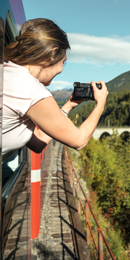 Landwasserviadukt (Foto: © Schweiz Tourismus / André Meier) Eine Passagierin der Rhätischen Bahn fotografiert das Landwasserviadukt