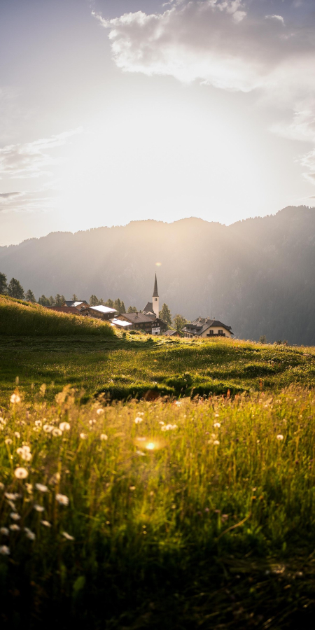 Abendstimmung im Safiental: Das Bergdorf Tenna liegt idyllisch eingebettet zwischen blühenden Wiesen und imposanten Bergen (Foto: © Marco Hartmann) Blick auf das Bergdorf Tenna im Safiental bei Sonnenuntergang