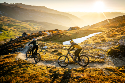 © LAAX / Weisse Arena Gruppe / Philipp Ruggli Eine Mountainbikerin und ein Mountainbiker auf einem Trail in der Ferienregion Flims Laax Falera