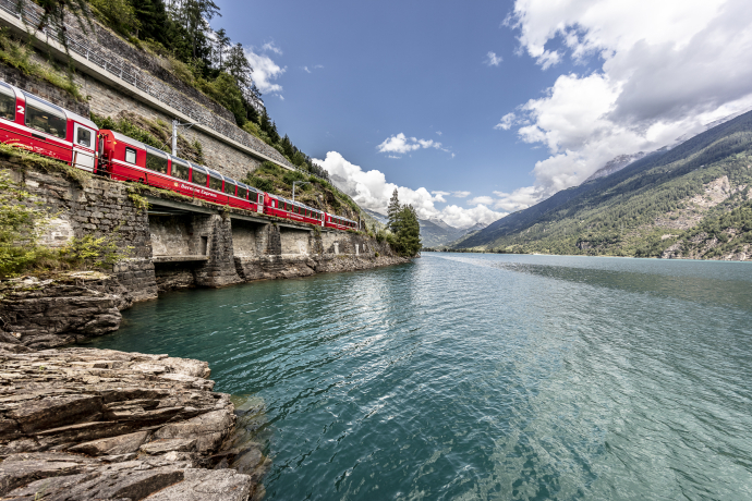 Der Bernina Express der Rhätischen Bahn am Lago di Poschiavo (Foto: © Rhätische Bahn / Andrea Badrutt) Der Bernina Express der Rhätischen Bahn am Lago di Poschiavo