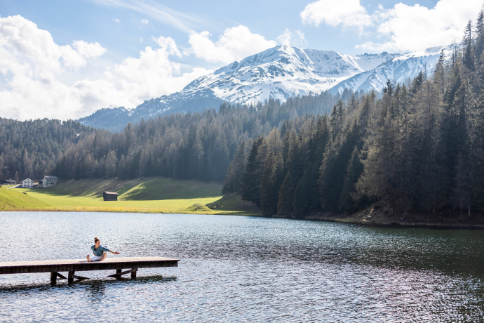 Yoga am Schwarzsee in Davos (Foto: Destination Davos Klosters / Martin Bissig) Frau macht Yoga-Übung am Schwarzsee in Davos