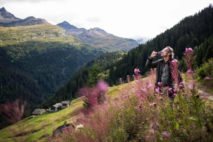 Bergluft-Sommelier Patrick Stebler in Vals (Foto: © Marco Hartmann) Bergluft-Sommelier Patrick Stebler riecht an einer Blume in Vals