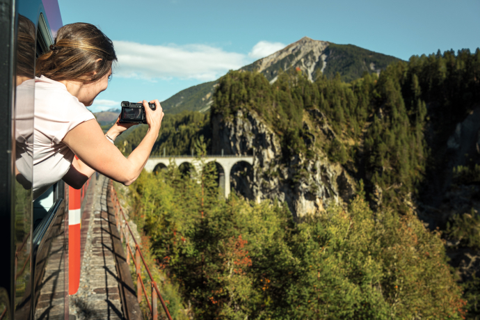 Landwasserviadukt (Foto: © Schweiz Tourismus / André Meier) Eine Passagierin der Rhätischen Bahn fotografiert das Landwasserviadukt