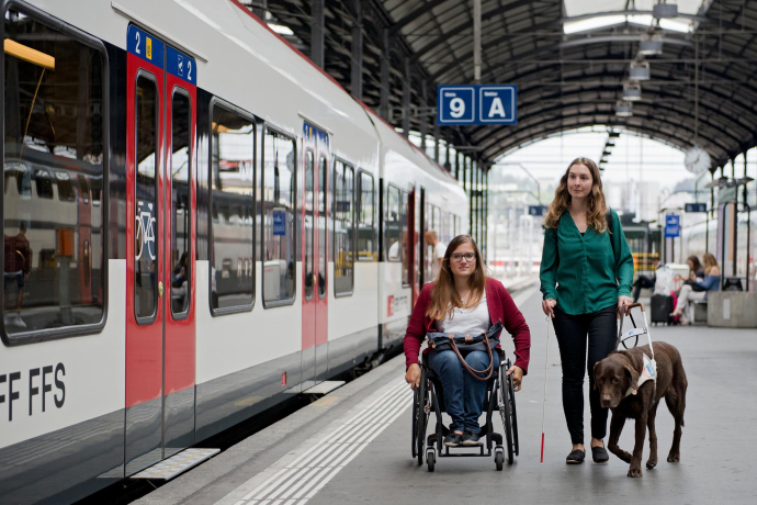 Der Tiefeinstieg zahlreicher Züge erleichtert das Ein- und Aussteigen an vielen Bahnhöfen (Foto: © SBB CFF FFS) Eine Frau im Rollstuhl und eine Frau mit einem Blindenführhund auf einem Bahnhofperron