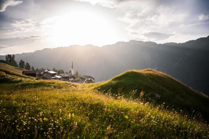 Abendstimmung im Safiental: Das Bergdorf Tenna liegt idyllisch eingebettet zwischen blühenden Wiesen und imposanten Bergen (Foto: © Marco Hartmann) Blick auf das Bergdorf Tenna im Safiental bei Sonnenuntergang