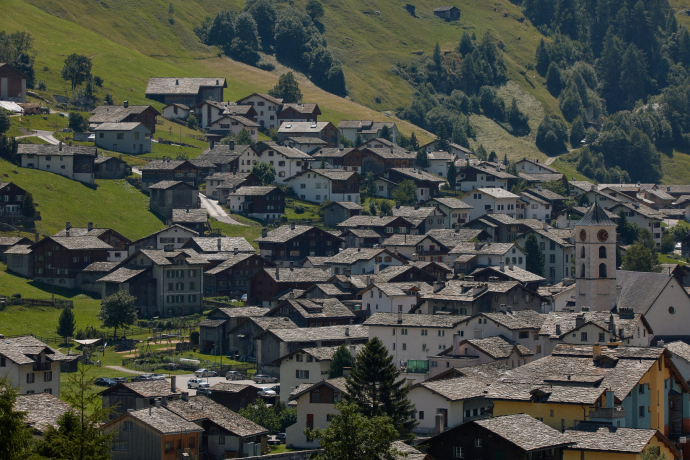 Sommertag im Bergdorf Vals mit Blick auf die traditionelle Bauweise und grüne Hügel (Foto: © 7132 Hotel / Julien Balmer) Bergdorf Vals im Sommer mit grünen Wiesen und typischen Steindächern