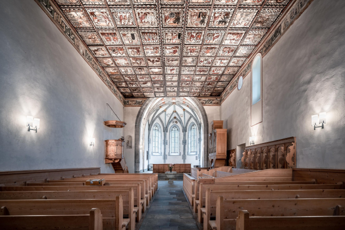 Die Kirche St. Martin in Zillis beeindruckt mit ihrer einzigartigen bemalten Decke aus dem 12. Jahrhundert (Foto: © Tolis Fragoudis) Blick ins Innere der Kirche St. Martin in Zillis mit bemalter Holzdecke und historischen Kirchenbänken