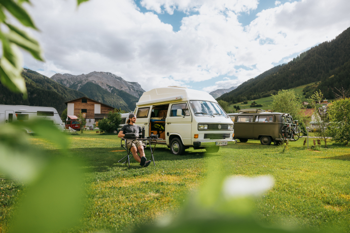 Entspanntes Camping im Val Müstair mit Blick auf die umliegenden Berge (Foto: © Roman Huber) Camping Muglin in Müstair mit Camper und VW-Bus vor Bergkulisse