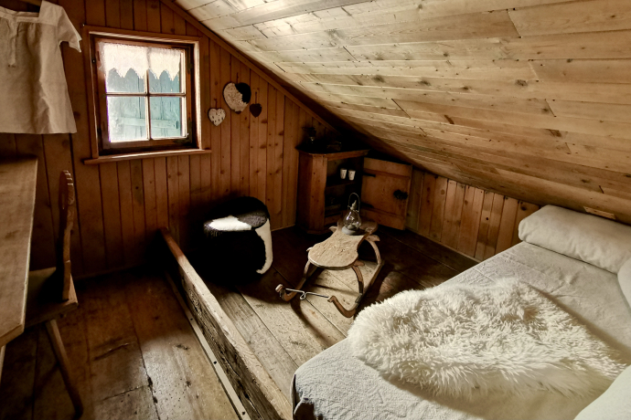 Nostalgisch-verträumt: Im Berghaus Heimeli in Sapün schlafen Gäste in 300 Jahre alten Mauern (Foto: © Heimeli Swiss AG) Rustikales Zimmer im Berghaus Heimeli in Sapün mit knarrenden Holzdielen, antiken Bündner Bauernmöbeln und gemütlichem Flair