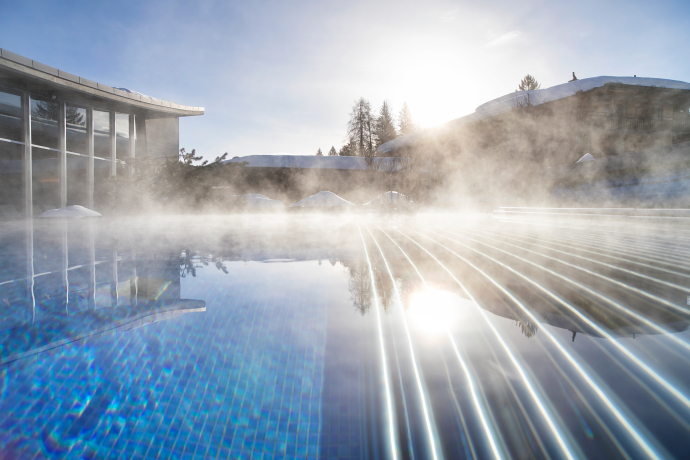Outdoor-Pool im La Mira Wellness & Spa im Hotel Adula in Flims Waldhaus (Foto: © Hotel Adula) Aussenpool des La Mira Wellness & Spa im Hotel Adula in Flims Waldhaus mit aufsteigendem Dampf an einem sonnigen Wintertag