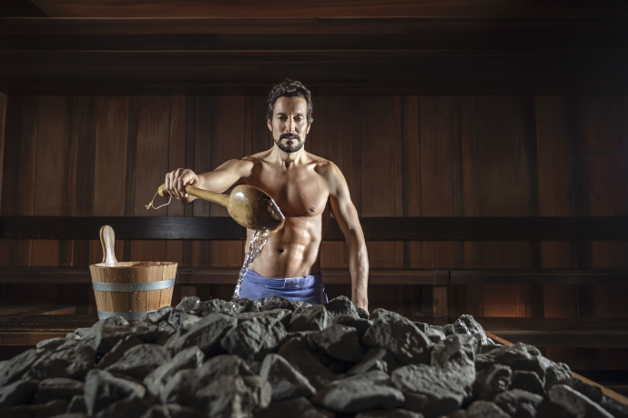 Aufguss im Saunadorf Ragaz – wohltuende Hitze und aromatische Düfte für ein besonderes Saunaerlebnis (Foto: © Grand Resort Bad Ragaz) Mann macht einen Saunaaufguss im Saunadorf Ragaz des Grand Resort Bad Ragaz
