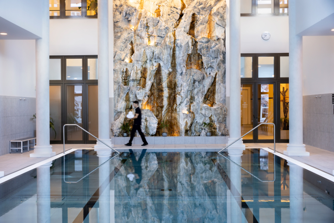 Indoor-Pool im Grand Hotel des Bains Kempinski St. Moritz (Foto: © Grand Hotel des Bains Kempinski St. Moritz) Eleganter Indoor-Pool mit Natursteinwand im Grand Hotel des Bains Kempinski St. Moritz