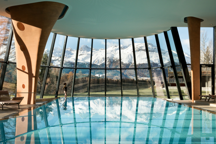 Indoor-Pool im Grand Hotel Kronenhof in Pontresina mit Blick auf die verschneiten Engadiner Berge (Foto: © Grand Hotel Kronenhof) Indoor-Pool mit Panoramafenstern und Bergblick im Grand Hotel Kronenhof in Pontresina