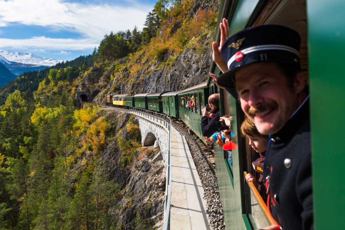 Kinder-Kondukteur Clà Ferrovia schaut aus dem Fenster eines historischen Zuges der Rhätischen Bahn