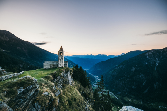 Die Kirche San Romerio thront spektakulär auf 1800 m oberhalb der Valposchiavo – ein stiller Ort mit Weitblick (Foto: © Christiane Setz-Müller & Moritz Müller) Bergkirche San Romerio oberhalb der Valposchiavo bei Sonnenaufgang