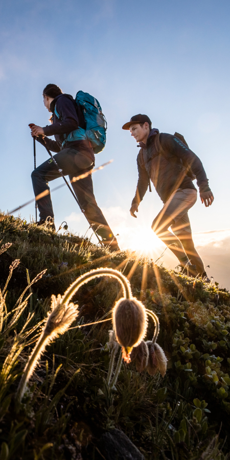 Ein Wanderpaar unterwegs bei Sonnenaufgang am Jakobshorn in der Region Davos Klosters