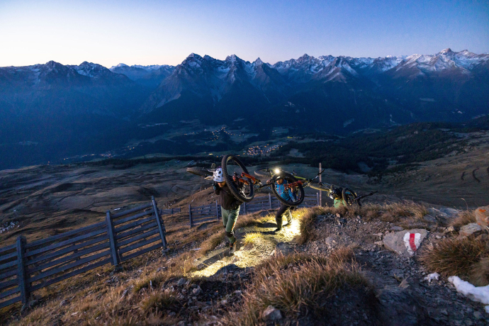 Mountainbiker wandern mit dem Bike dem Sonnenaufgang entgegen