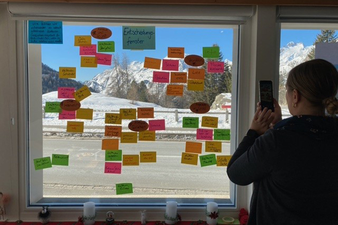 Im Workshop auch Wände oder Fenster nutzen Workshop-Teilnehmende kleben Post-Its auf Fensterscheibe